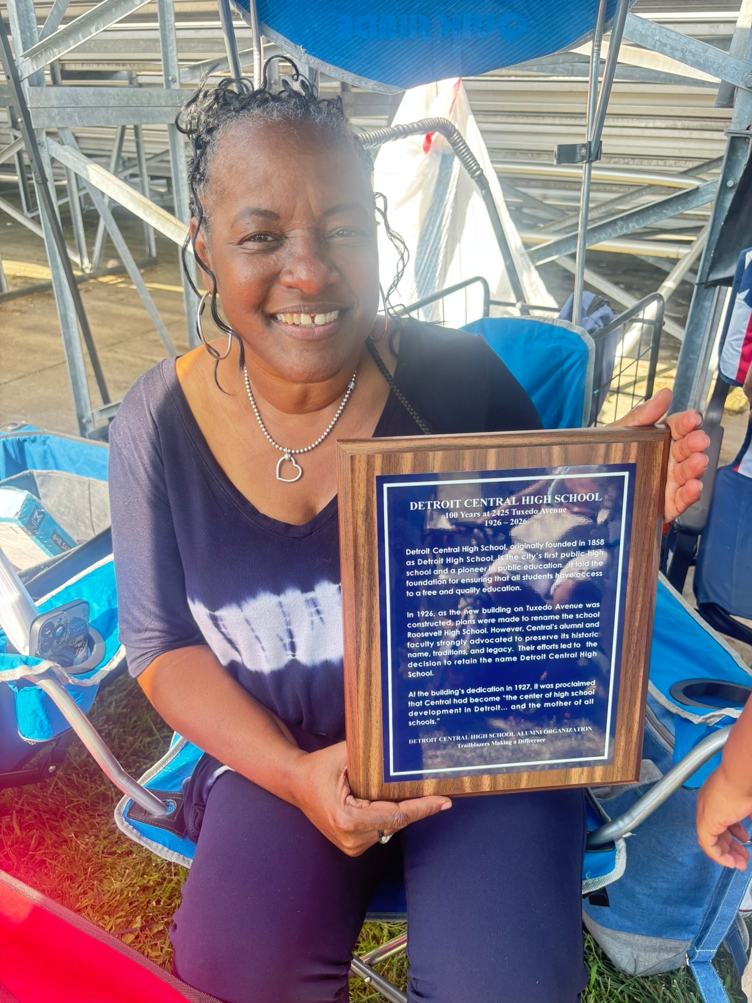 Woman holding Detroit Central High School plaque