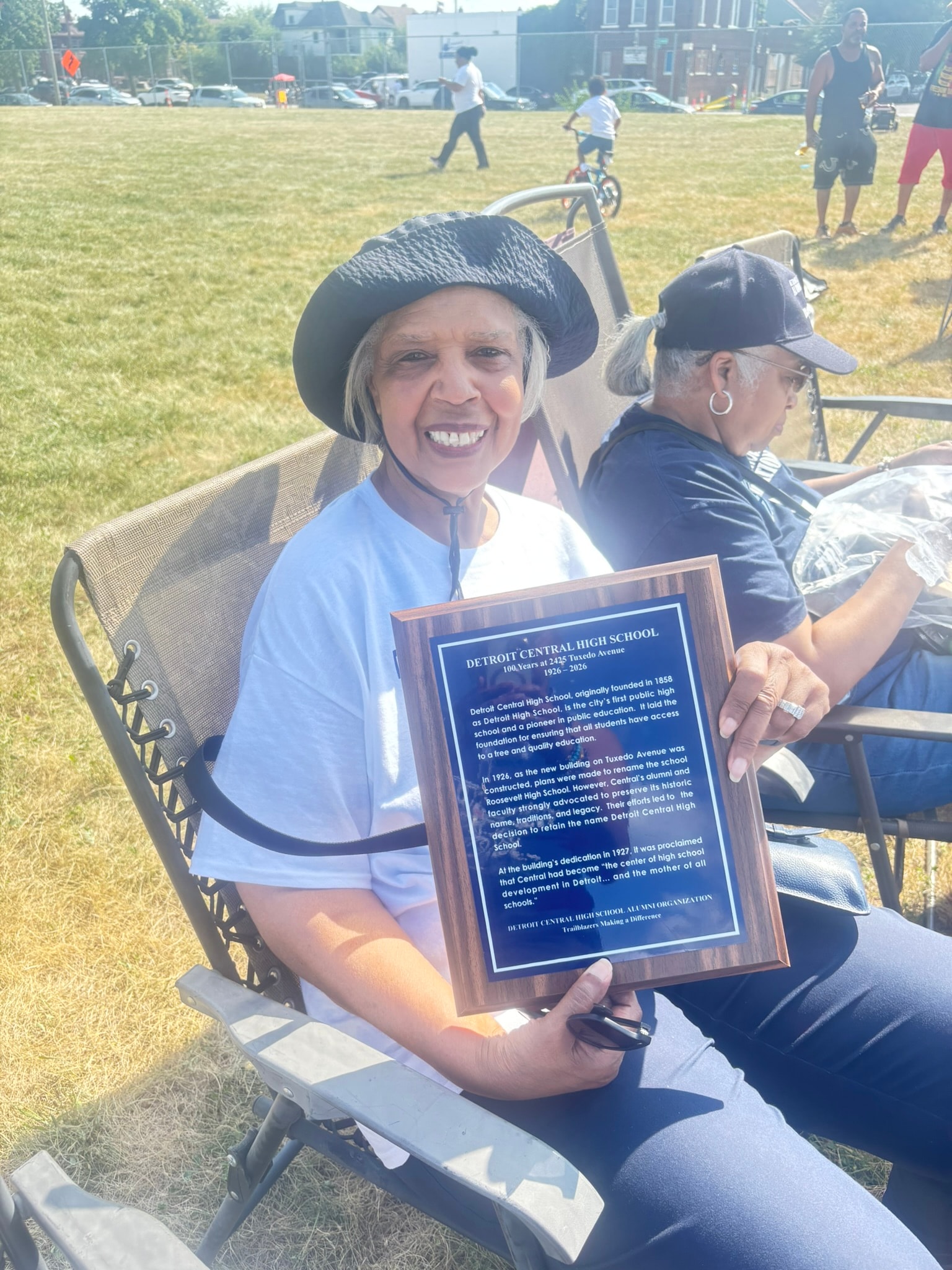 Woman holding Detroit Central High School plaque