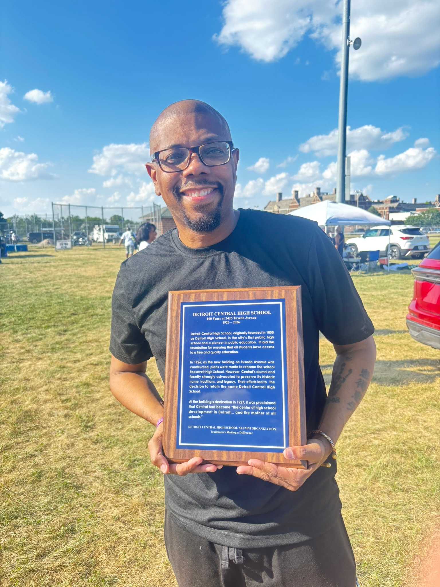 Man holding Detroit Central High School plaque