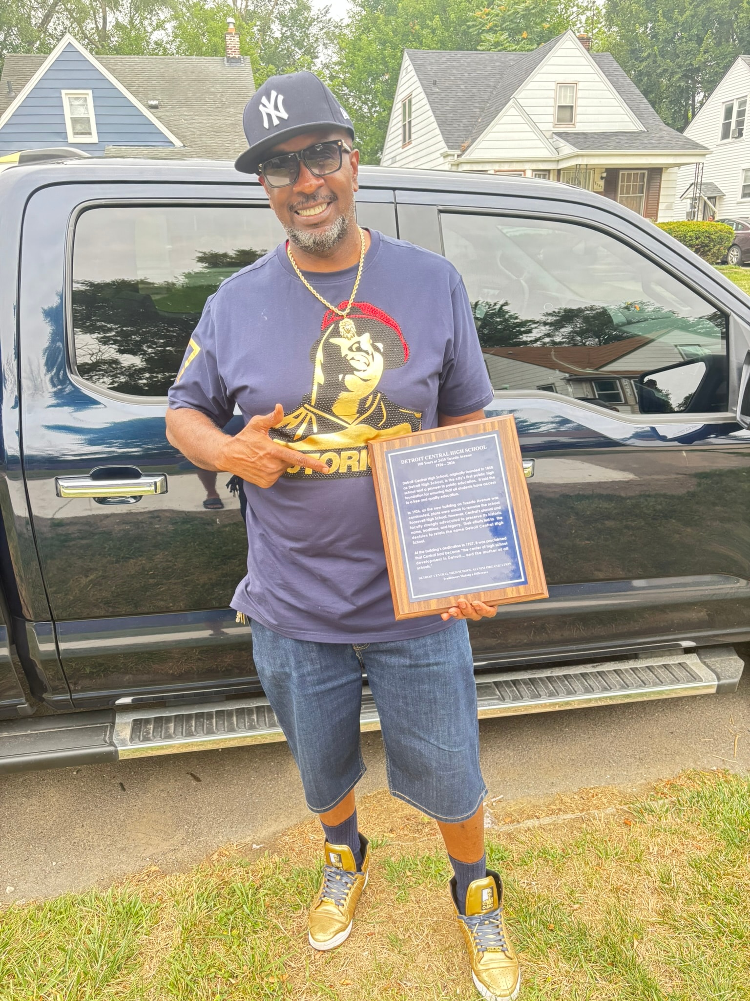 Man holding award plaque driveway