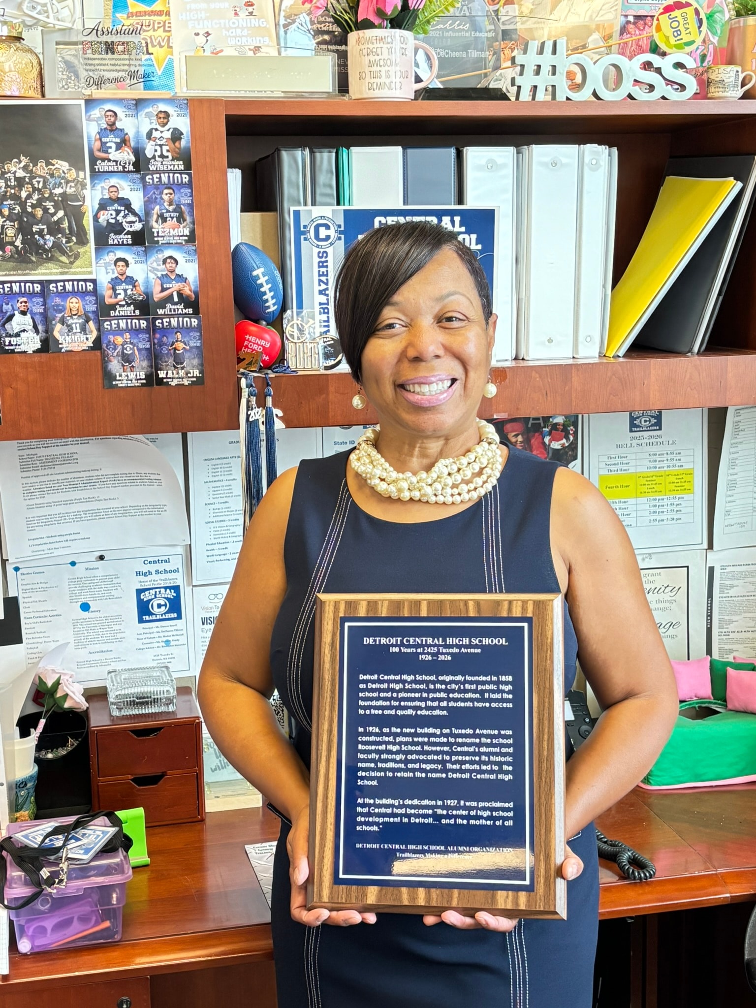 Woman holding Detroit Central High School plaque