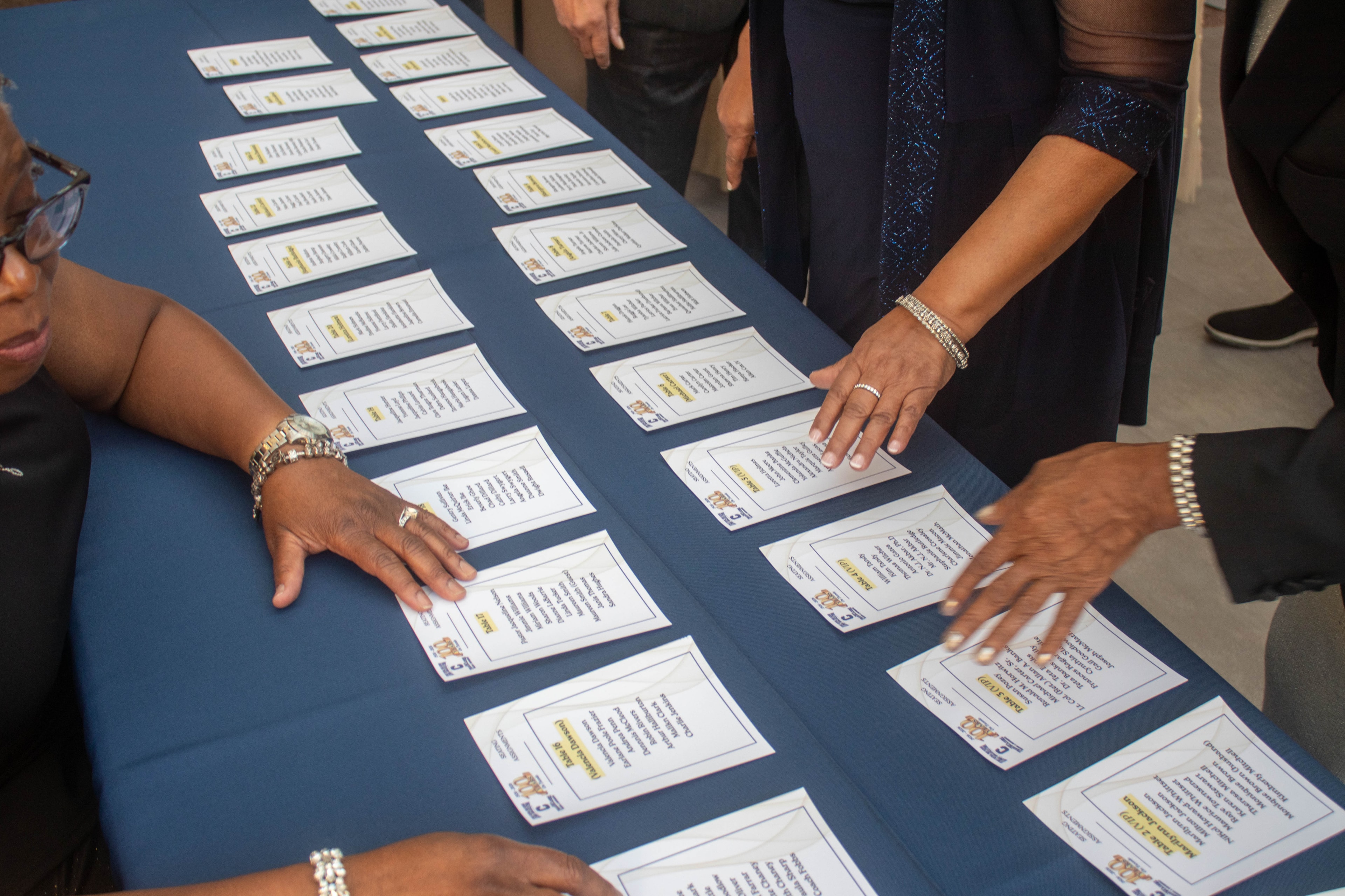 People viewing printed materials at table