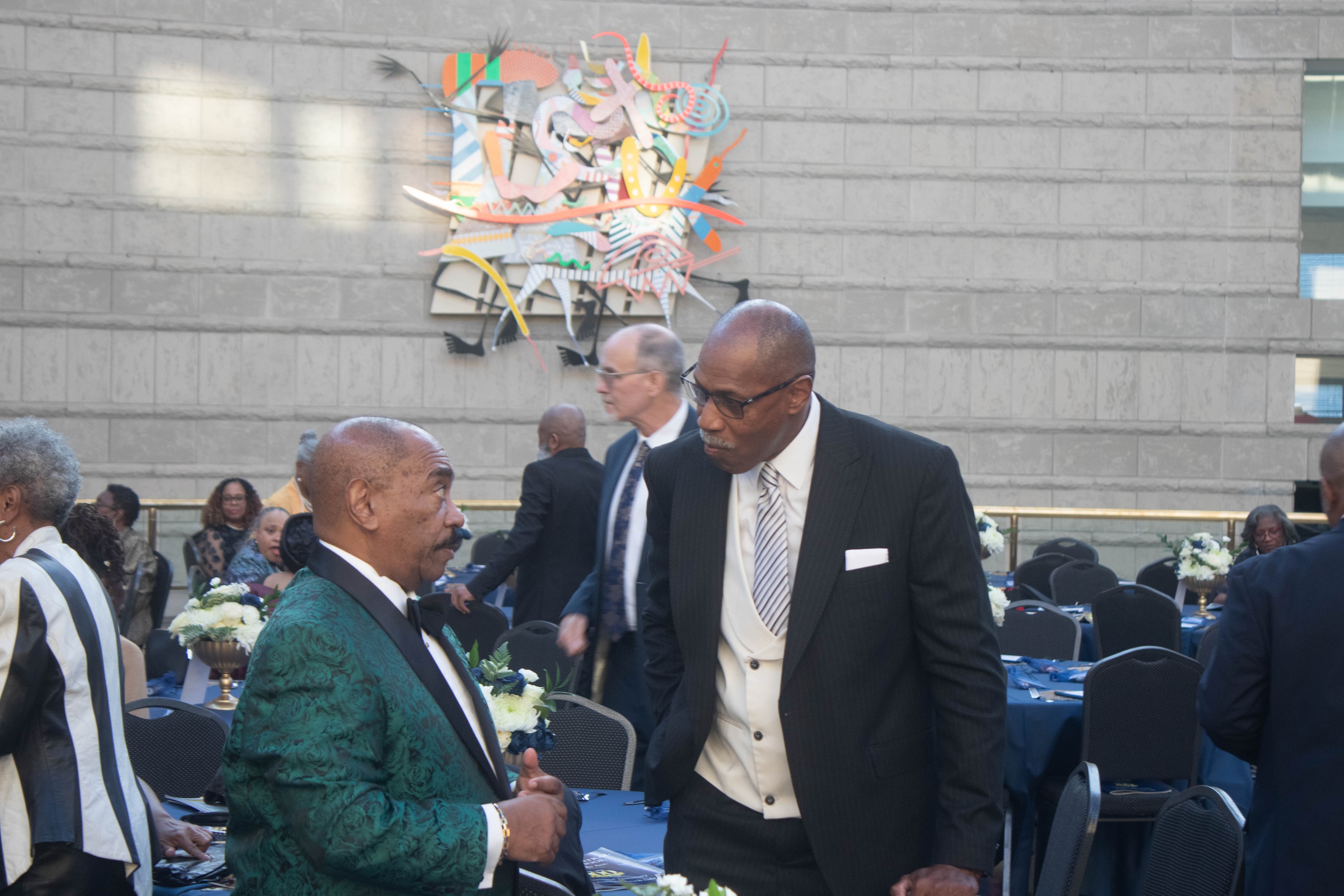 Formal event guests conversing outdoor venue