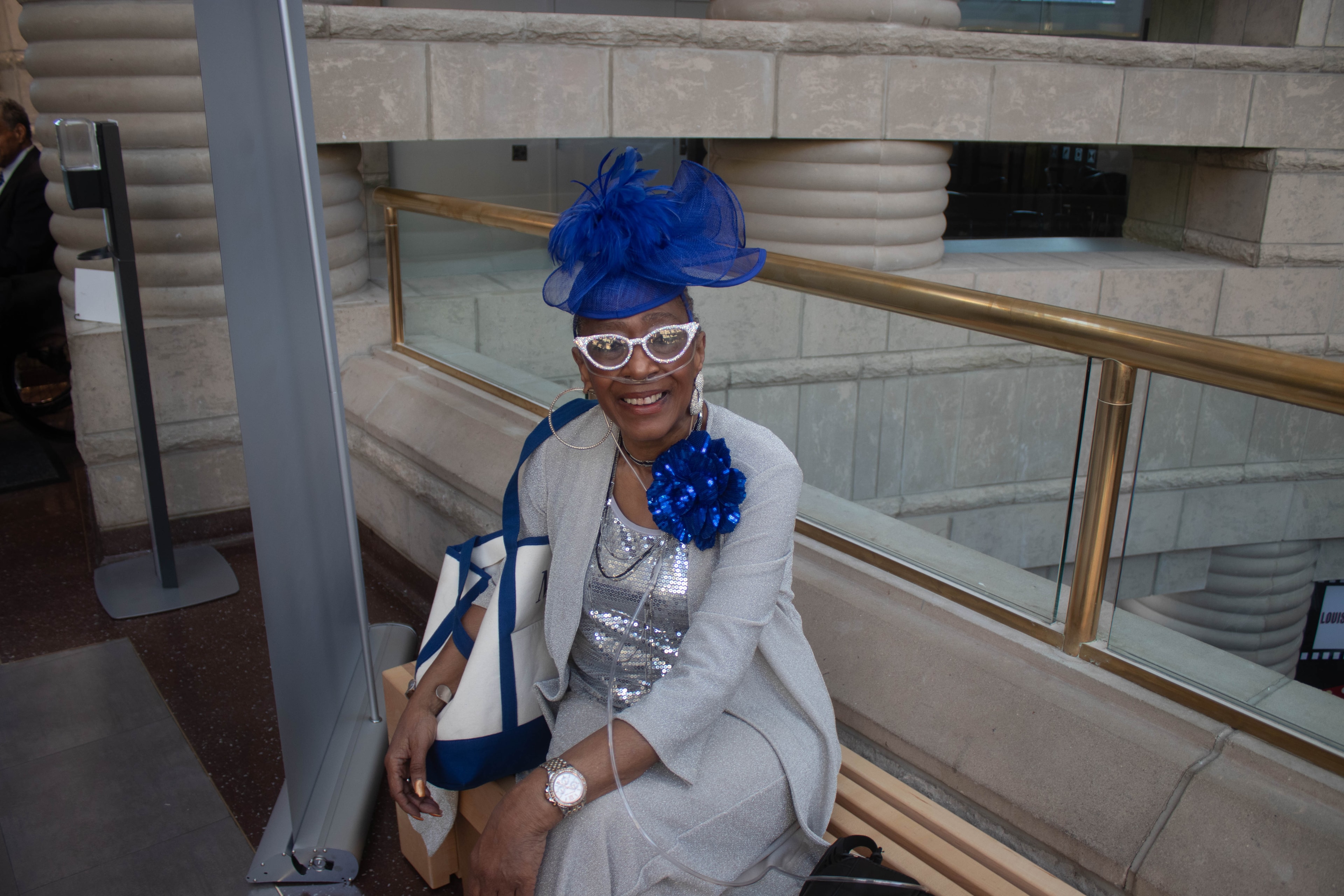 Woman in blue hat and sunglasses smiling indoors