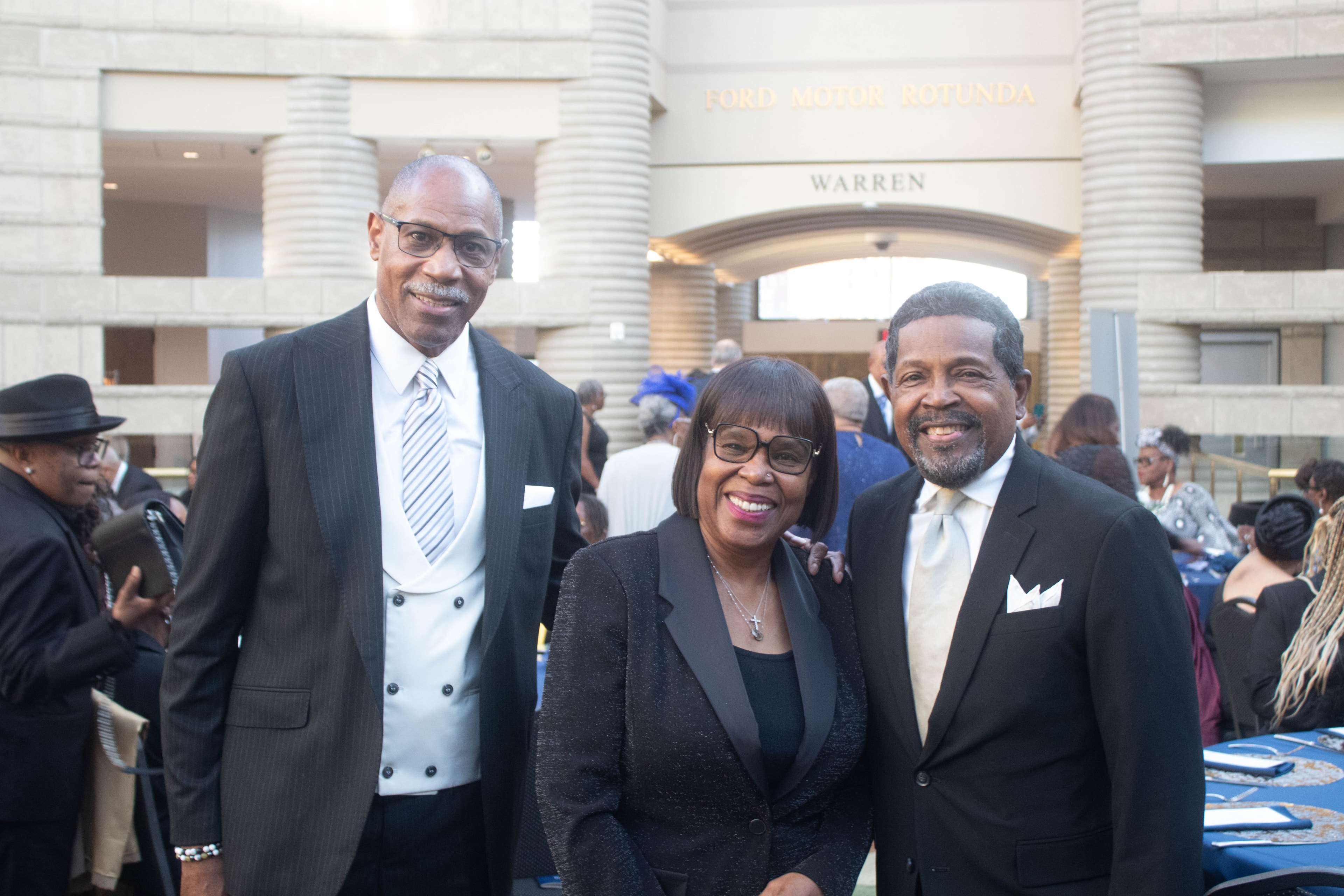 Three people posing at formal event