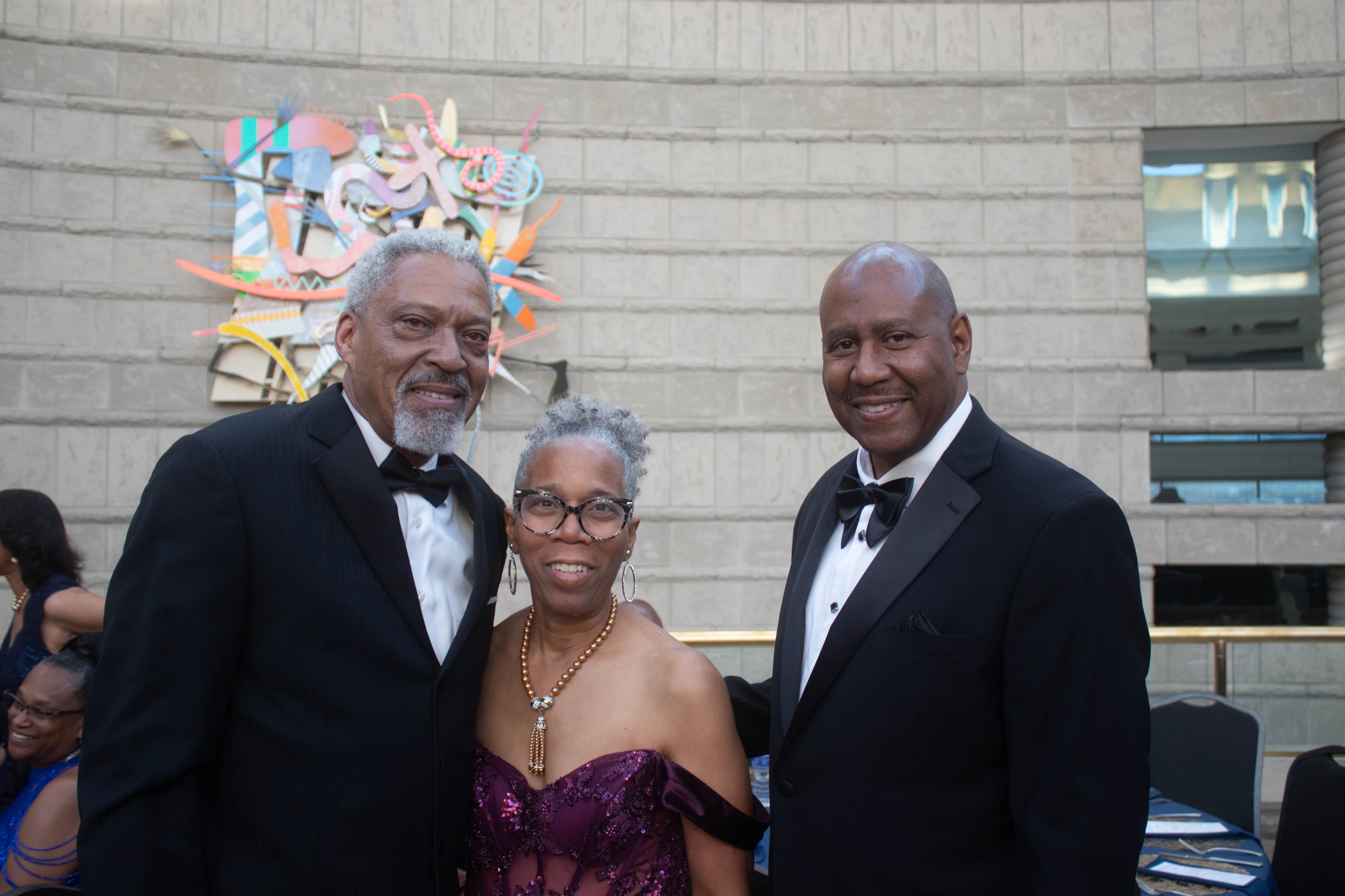 Three people formal attire museum event