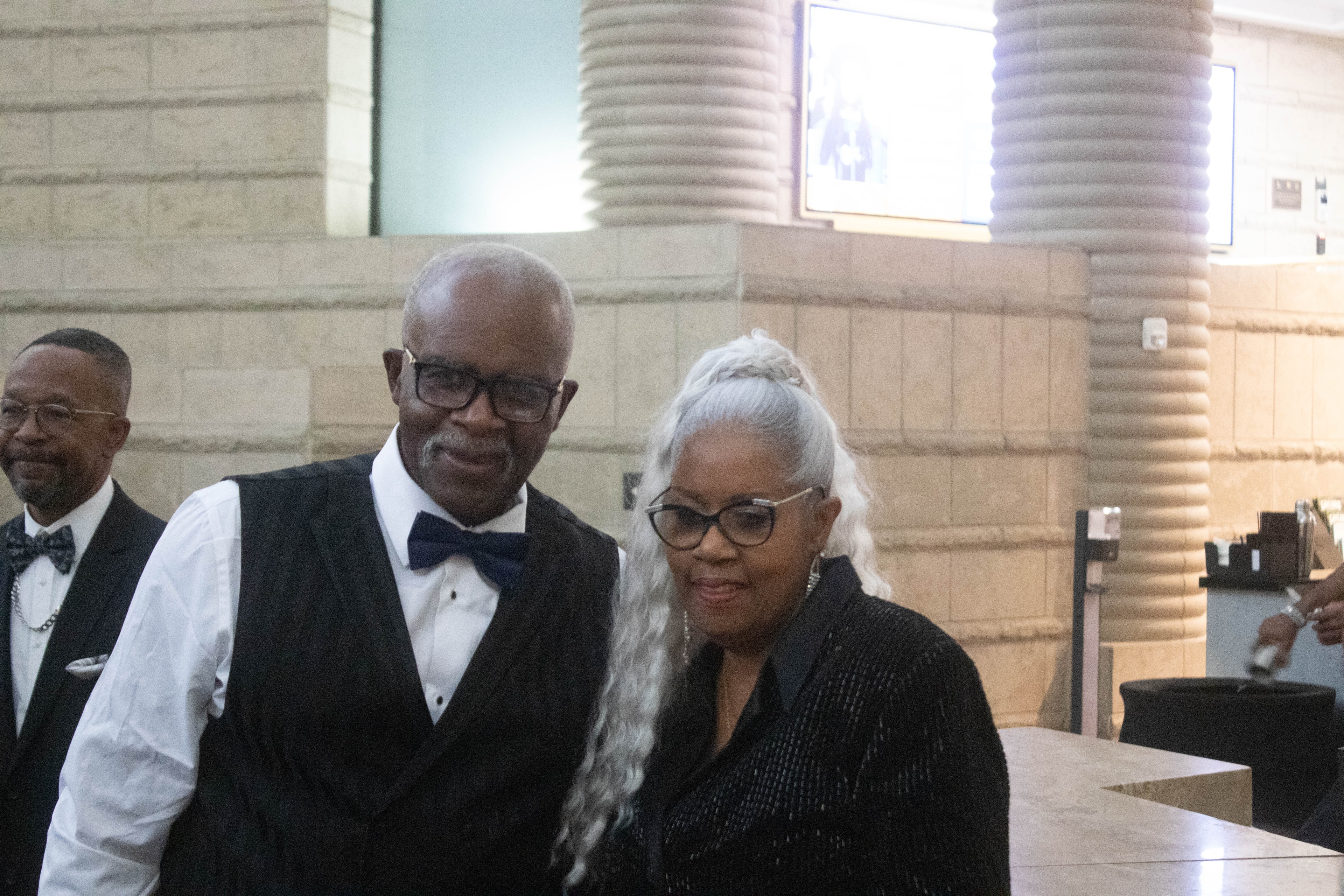 People in formal attire at indoor event