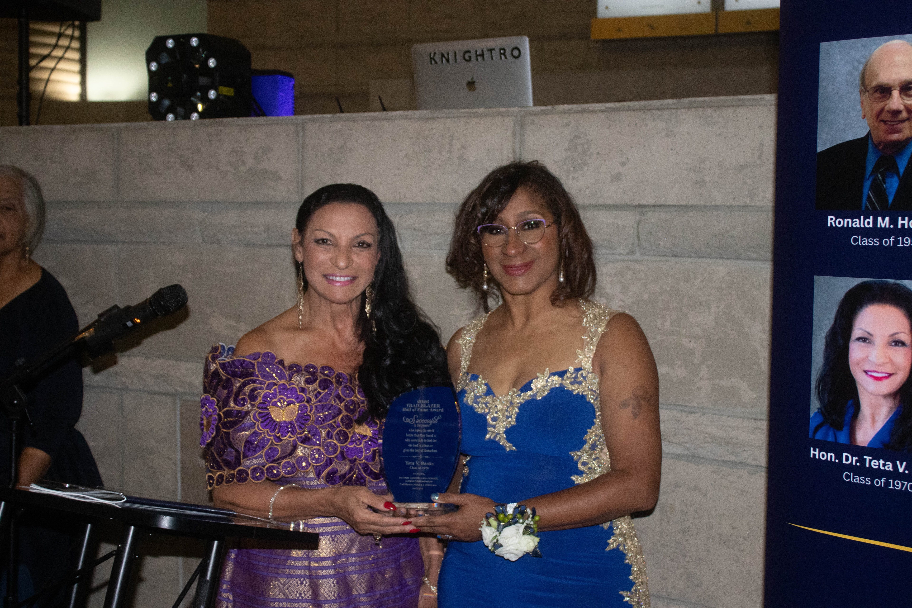 Two women holding award at formal event