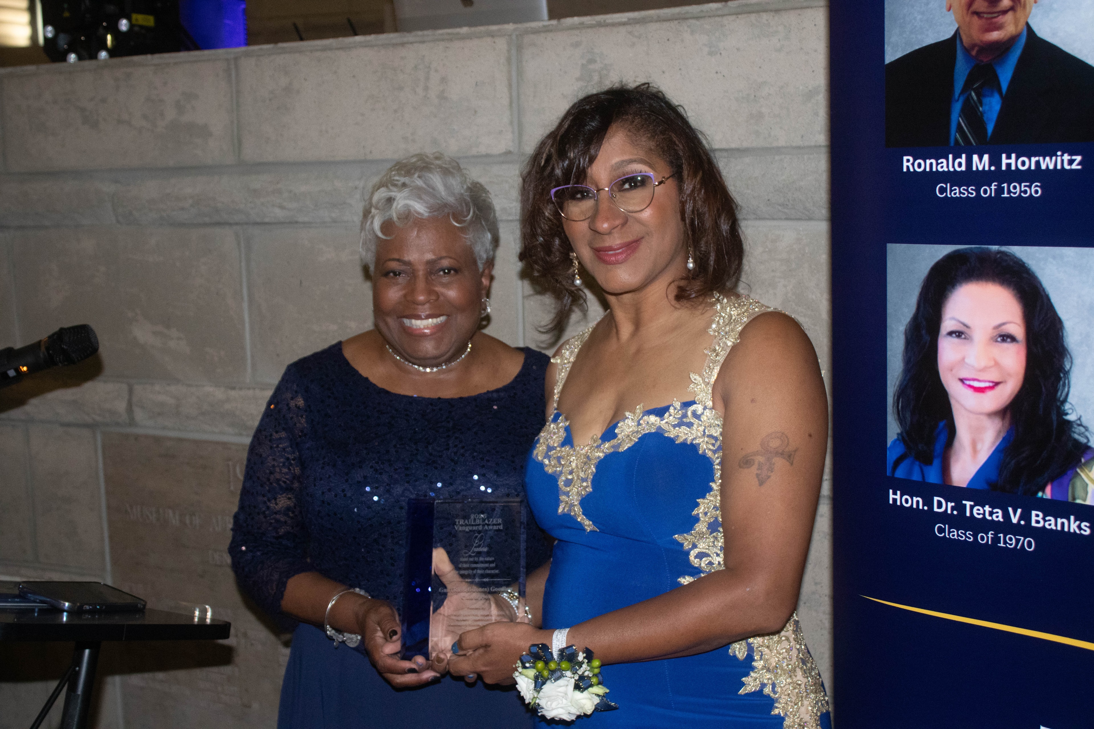 Two women holding award at formal event