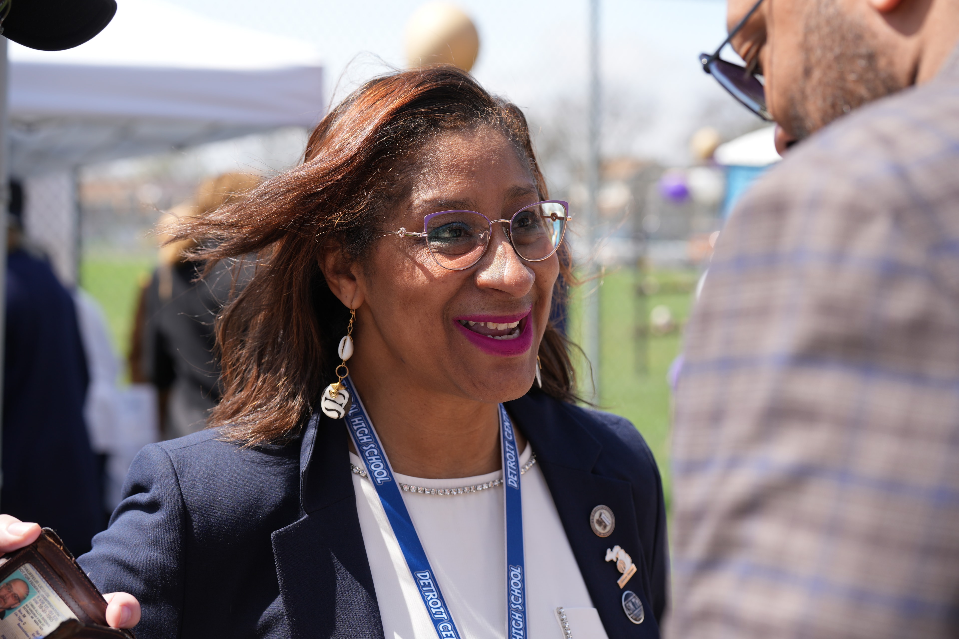 Woman wearing lanyard speaking at outdoor event